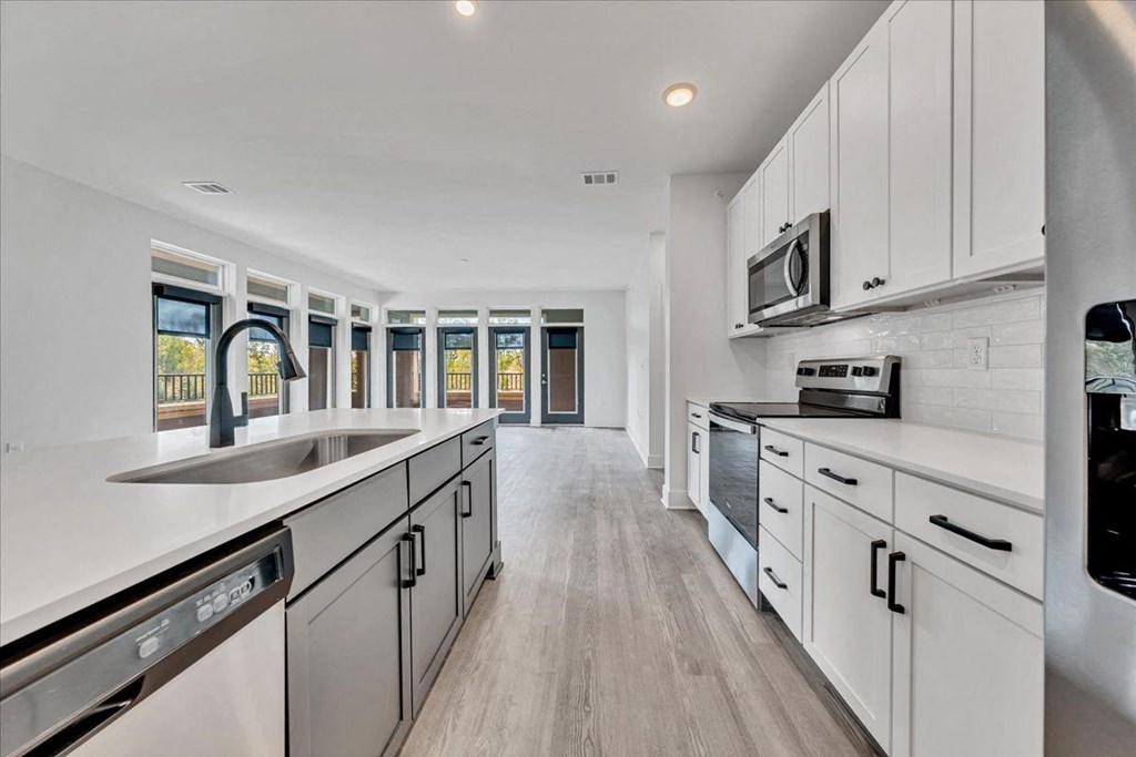 a large kitchen with white cabinets and a sink  at Luxe 360 on Centerpointe Apartments, Midlothian, VA, 23114