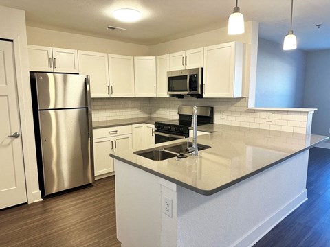 Modern kitchen with white shaker-style cabinets and stainless steel appliances  at Signature Pointe Apartment Homes, Athens, Alabama