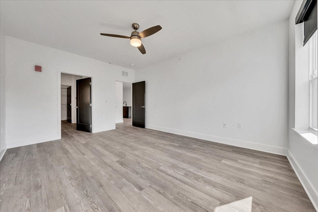 a living room with white walls and a ceiling fan at Luxe 360 on Centerpointe Apartments, Virginia