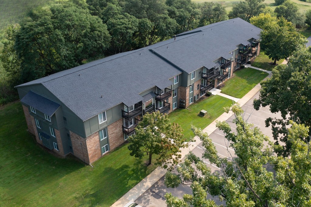 A large building with a grey roof and a green lawn in front