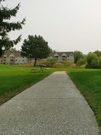 a sidewalk leading to a park with houses in the background at Windsor Place, Davison, 48423