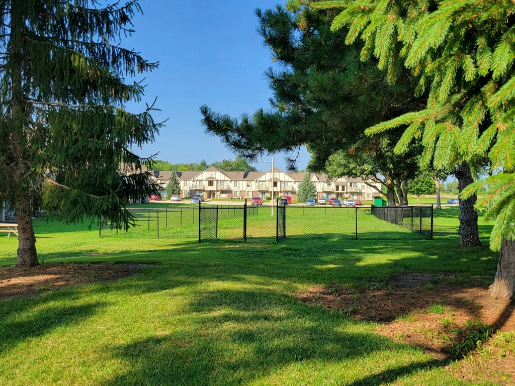 a large grassy area with trees in the foreground and houses in the background at Beacon Hill and Great Oaks Apartments, Illinois