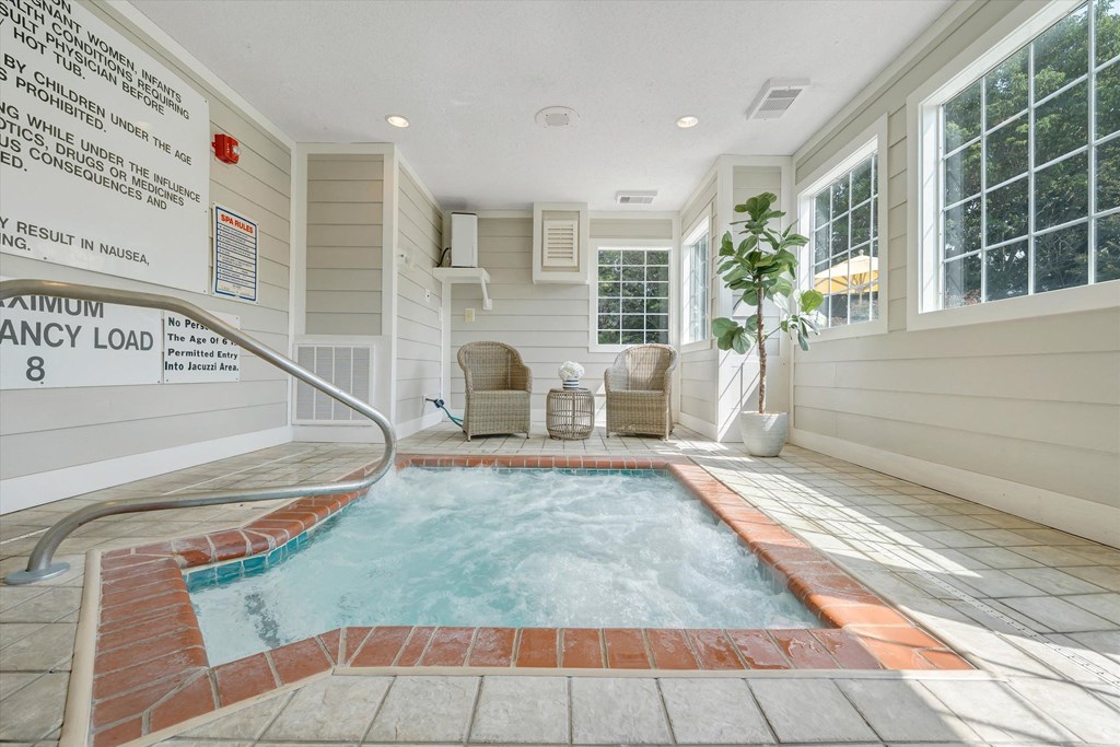 a hot tub with two chairs and a plant at Sunscape Apartments, Virginia