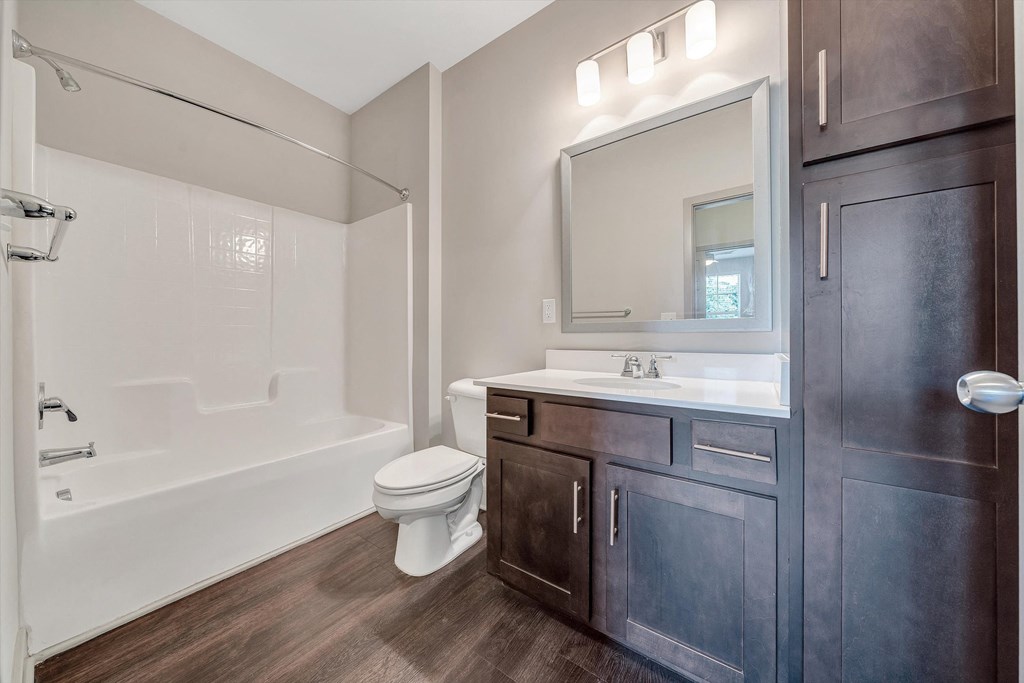 a bathroom with a toilet sink and shower and a mirror  at Avellan Springs Apartments, Morrisville