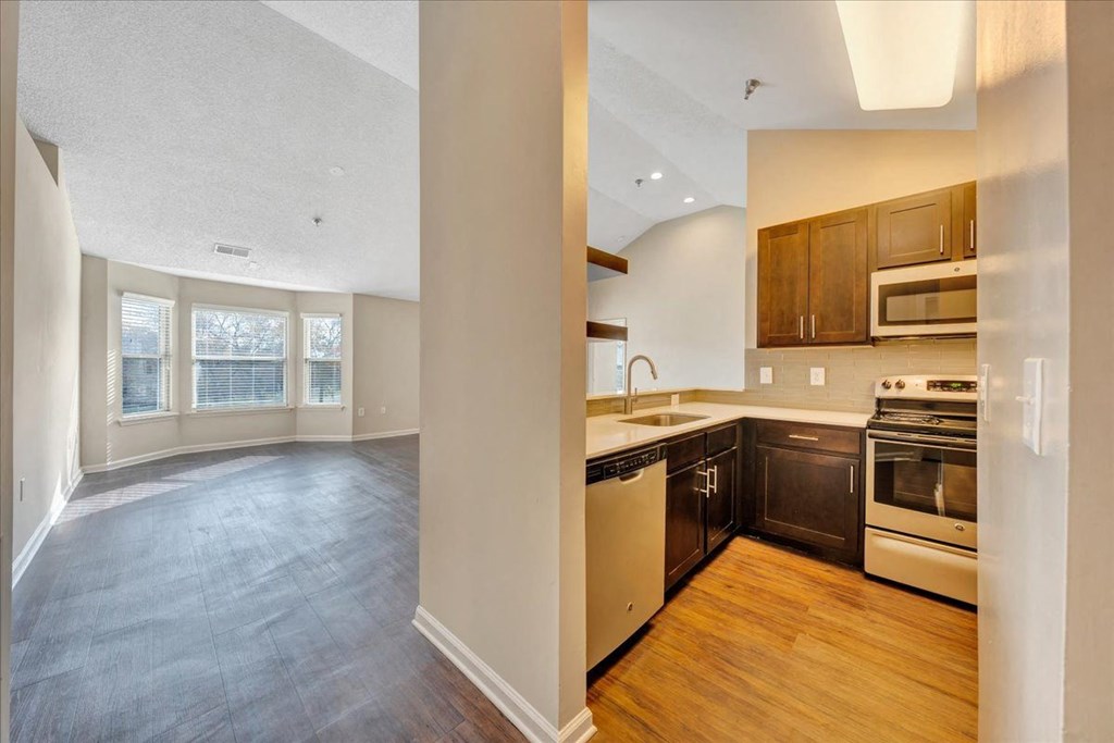 an empty kitchen and living room with wood flooring and