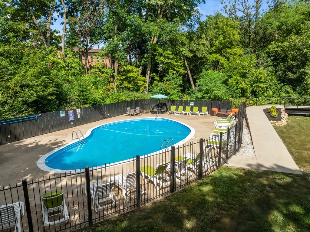 A pool surrounded by a fence and trees