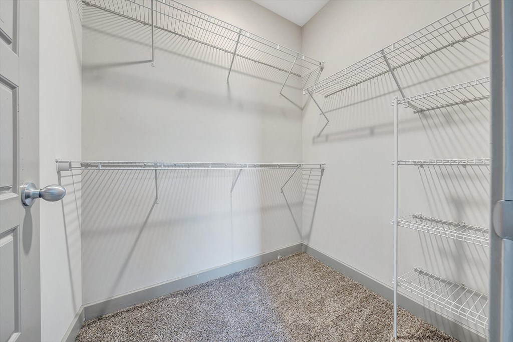 an empty closet with metal shelves in a room with a door  at Avellan Springs Apartments, Morrisville