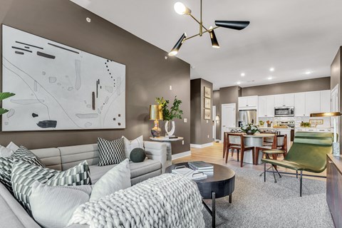 A modern living room with a grey sofa and a large abstract painting on the wall.