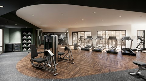 A gym with a variety of equipment including treadmills, weights, and exercise machines.