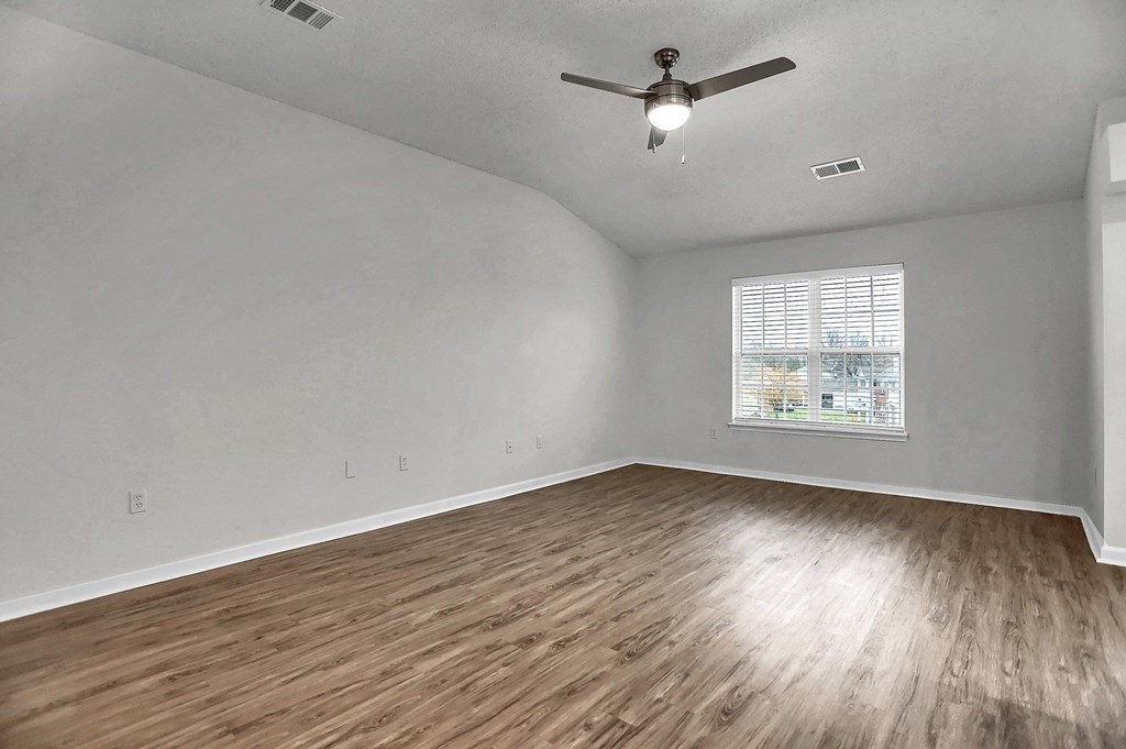 an empty living room with hardwood floors and a ceiling fan at Latitudes Apartments, Indianapolis, 46237