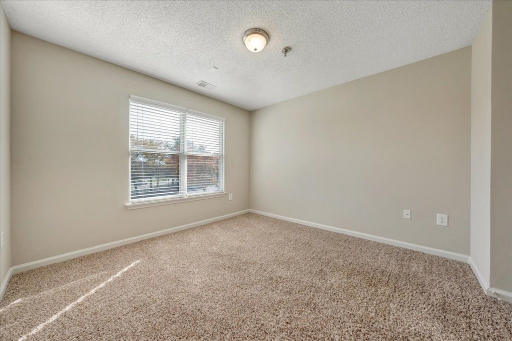 an empty room with carpet and a window