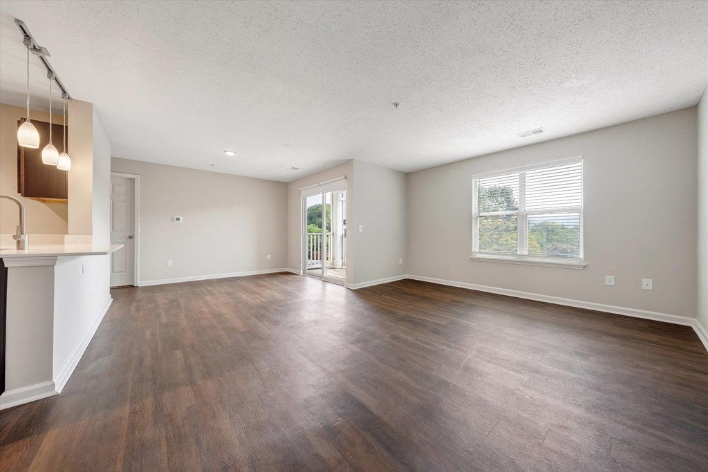 an empty living room with a kitchen in the background at Sunscape Apartments, Roanoke, VA, 24018