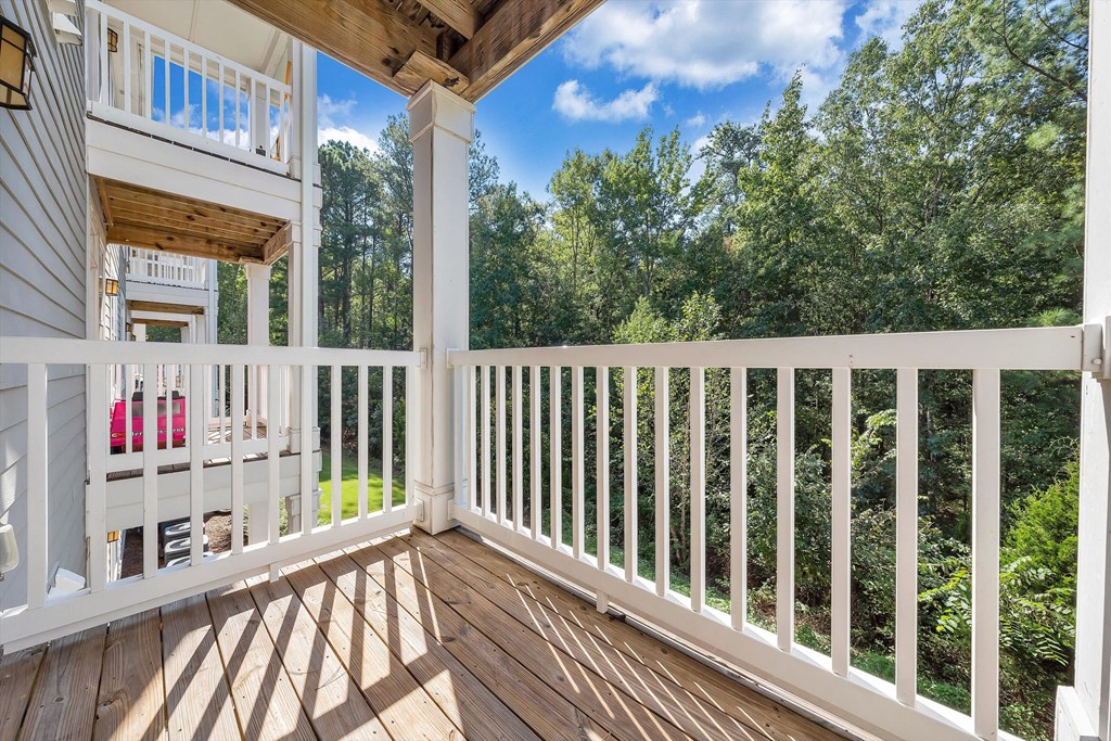 a balcony with a view of trees and a house  at Avellan Springs Apartments, Morrisville, NC, 27560