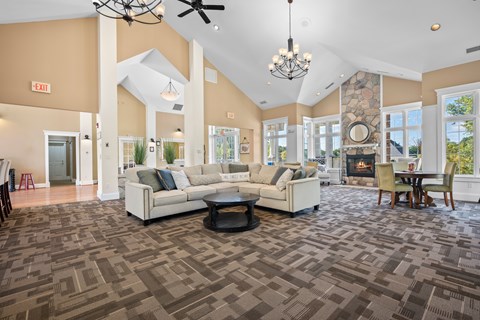 A spacious living room with a patterned carpet and a fireplace.