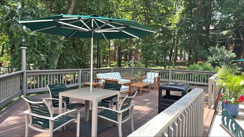 A patio with a table and chairs under an umbrella.