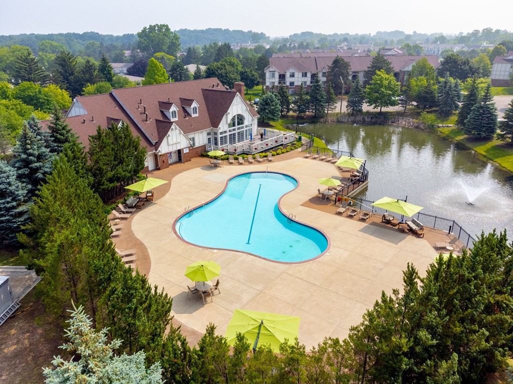 an aerial view of a resort style pool and spa with a house in the background at The Springs Apartment Homes, Novi