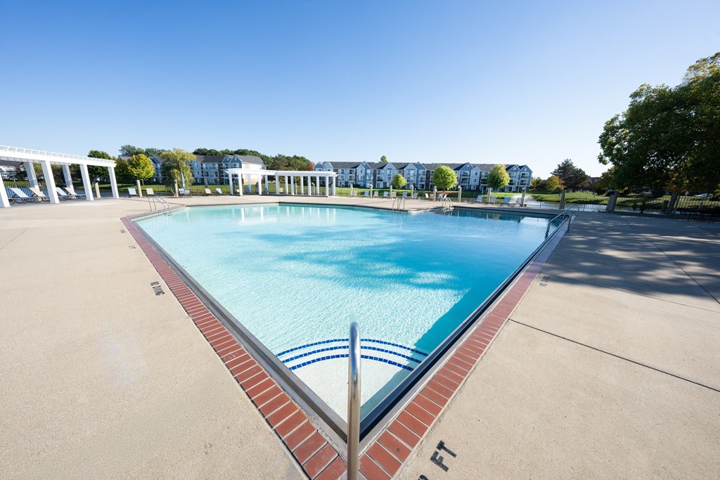 A large swimming pool with a red brick border.