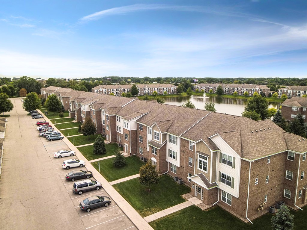 A row of houses with a parking lot in front.