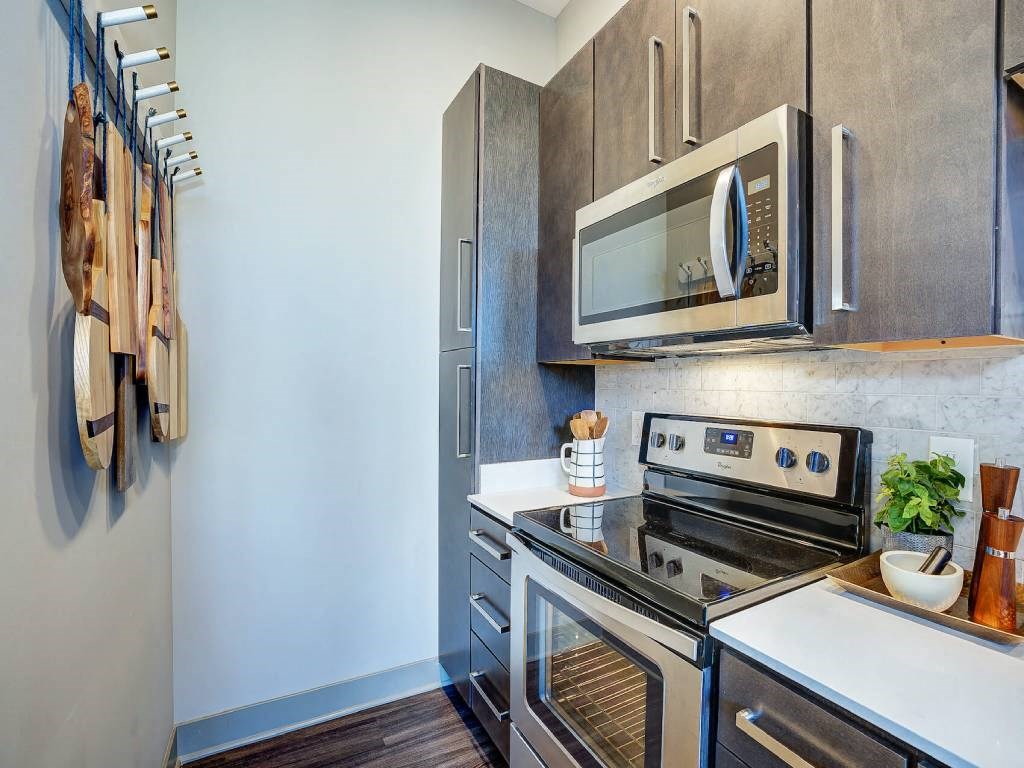 a kitchen with a stove top oven next to a microwave  at Avant & Avant II, Carmel, IN