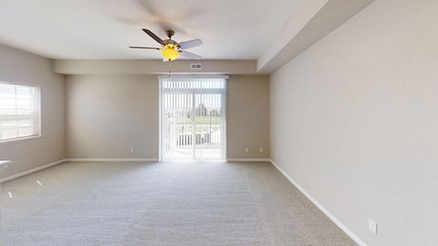 Spacious living area with ceiling fan and patio access at Andover Pointe Apartments Homes, La Vista, NE