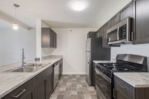 a kitchen with stainless steel appliances and marble counter tops