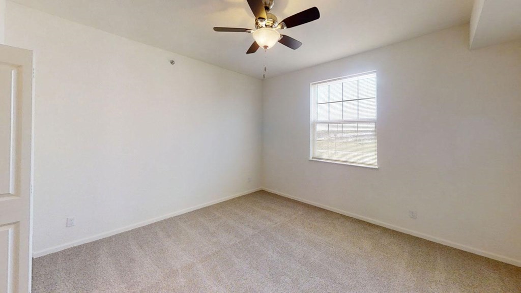 a bedroom with a ceiling fan and a windowat Andover Pointe Apartment Homes, La Vista