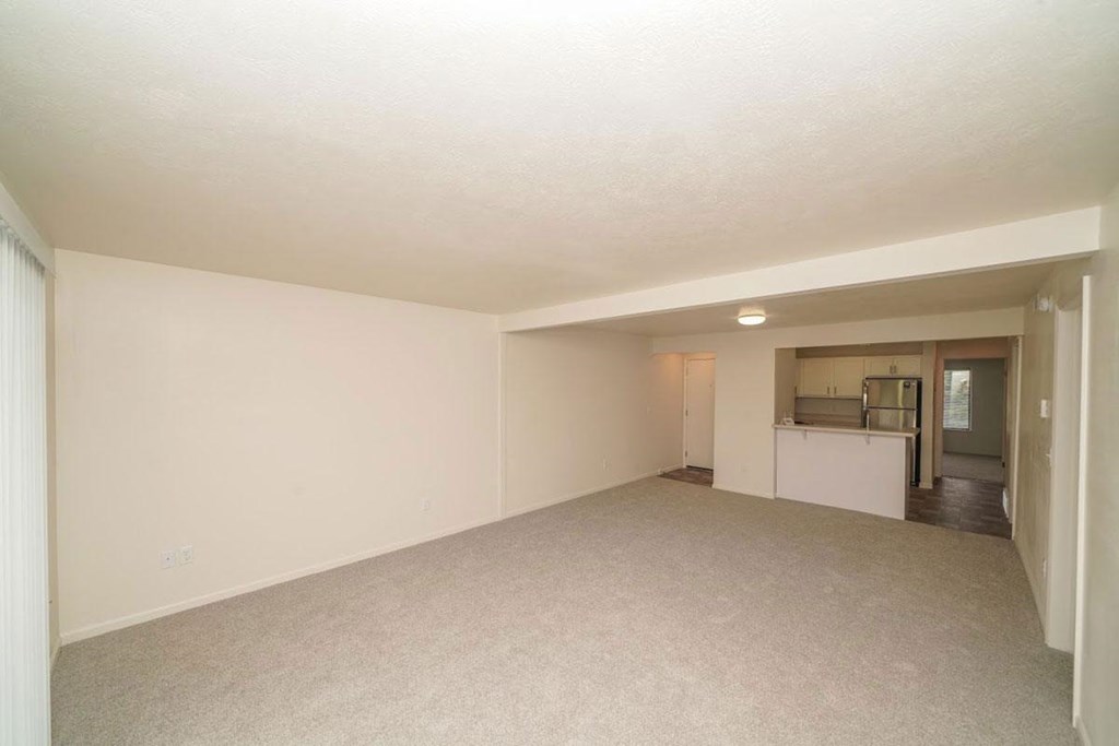 an empty living room with a kitchen in the backgroundat Arbor Lakes Apartments in Elkhart, IN