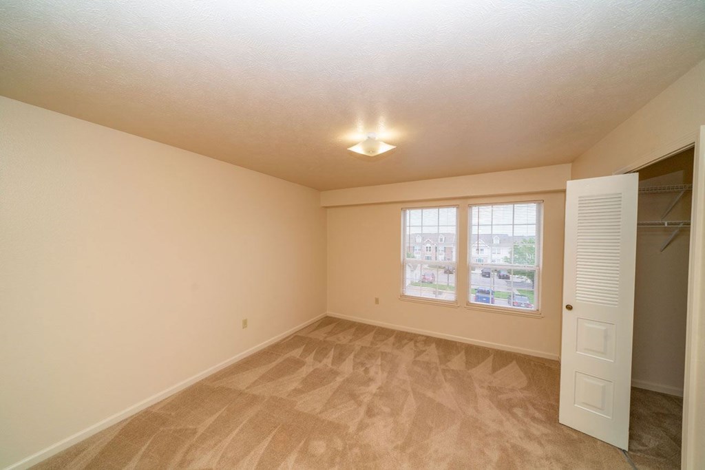 an empty bedroom with a walk-in closet and windows at Autumn Lakes Apartments and Townhomes, Mishawaka, IN