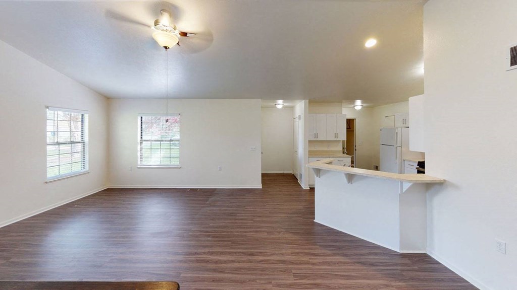 an empty living room with hard-surface flooring and a ceiling fan at Autumn Lakes Apartments and Townhomes, Indiana