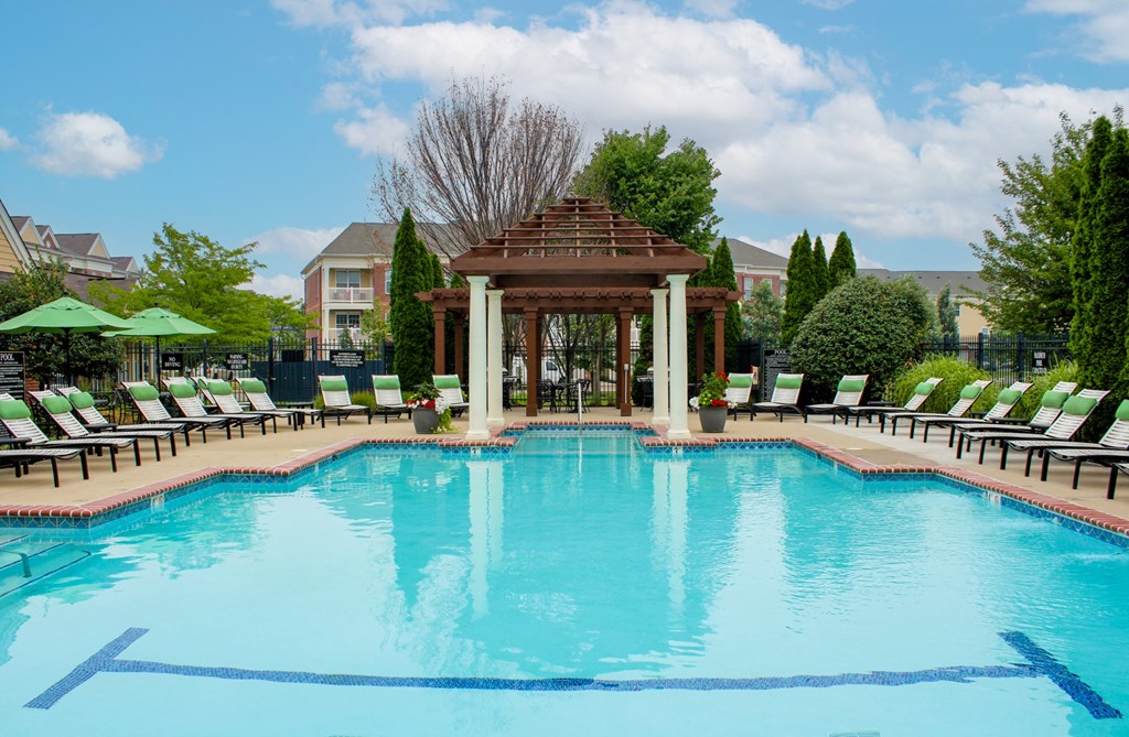 a pool with a gazebo and lounge chairs at Alexandria of Carmel Apartments, Indiana