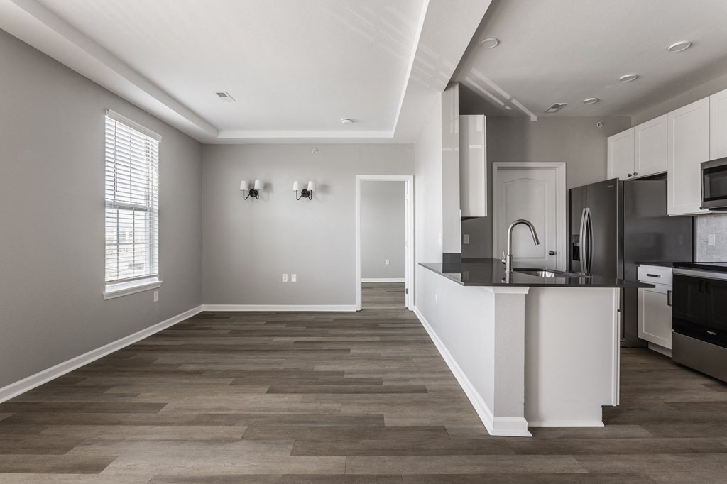 an open kitchen and living room with a large window and a black and white at Alexandria of Carmel Apartments, Carmel, Indiana