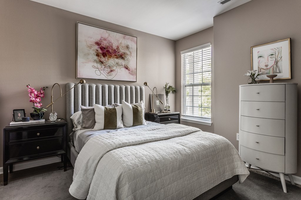 a bedroom with a bed and a dresser at Alexandria of Carmel Apartments, Carmel, Indiana