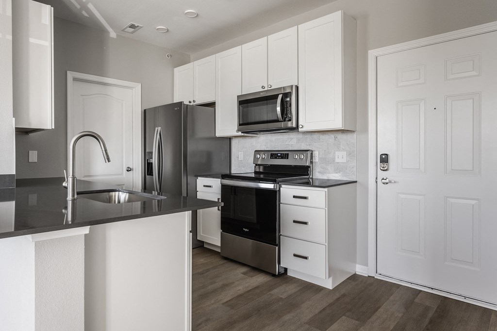 a kitchen with white cabinets and stainless steel appliances at Alexandria of Carmel Apartments, Indiana