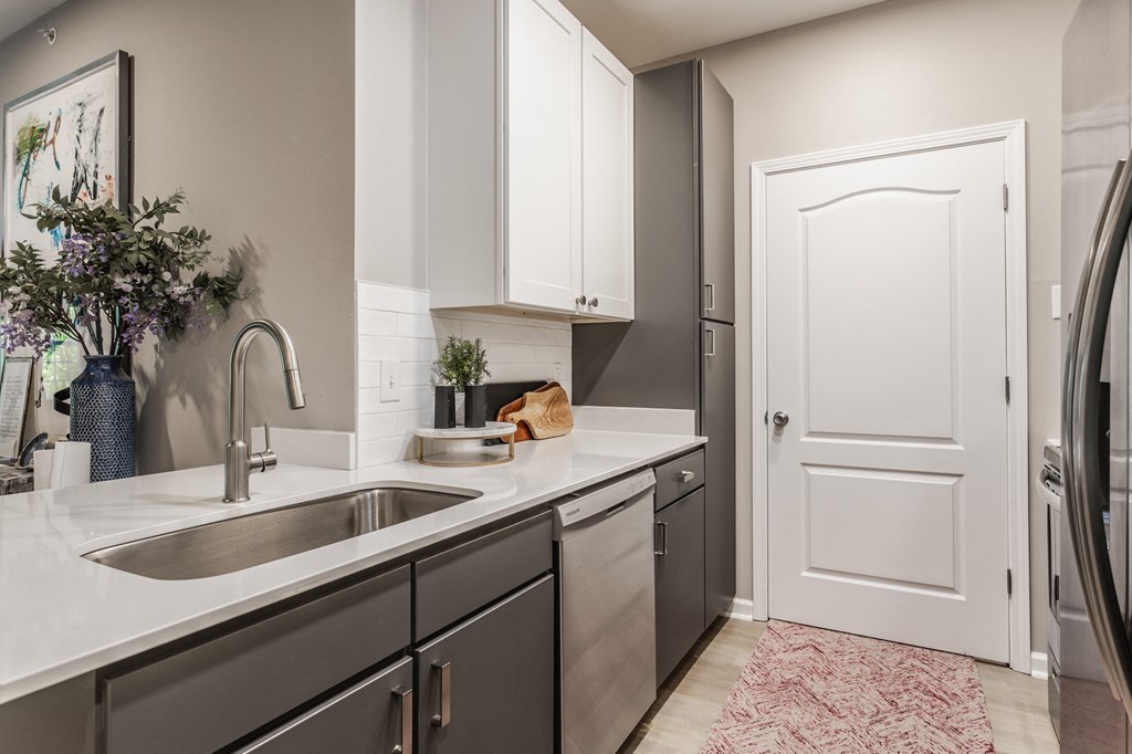 an empty kitchen with a sink and a door to a laundry room at Alexandria of Carmel Apartments, Carmel