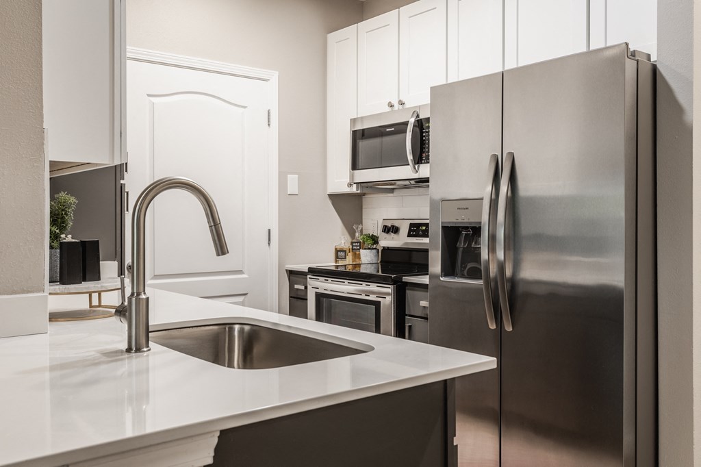 a kitchen with stainless steel appliances and a sink at Alexandria of Carmel Apartments, Indiana