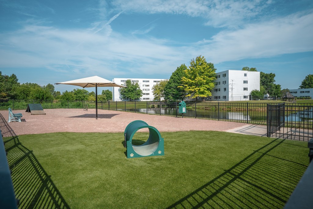 A playground with a green slide and a white building in the background.