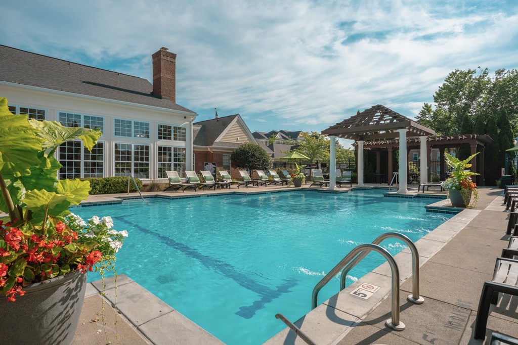 A large swimming pool with a diving board and a building in the background.