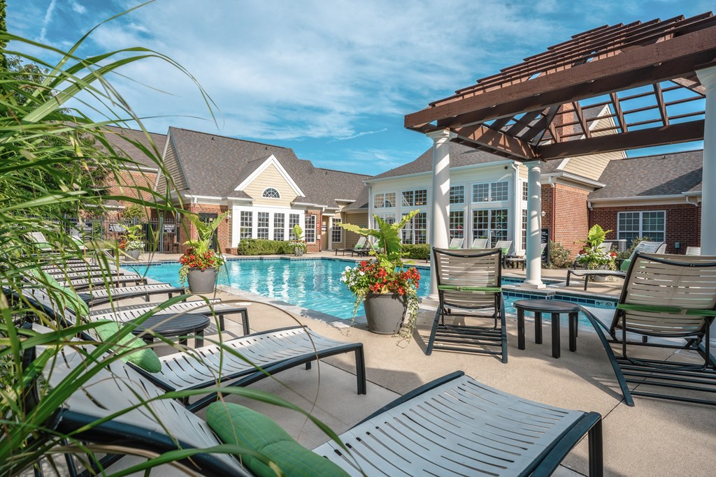 A poolside area with lounge chairs and a pool.