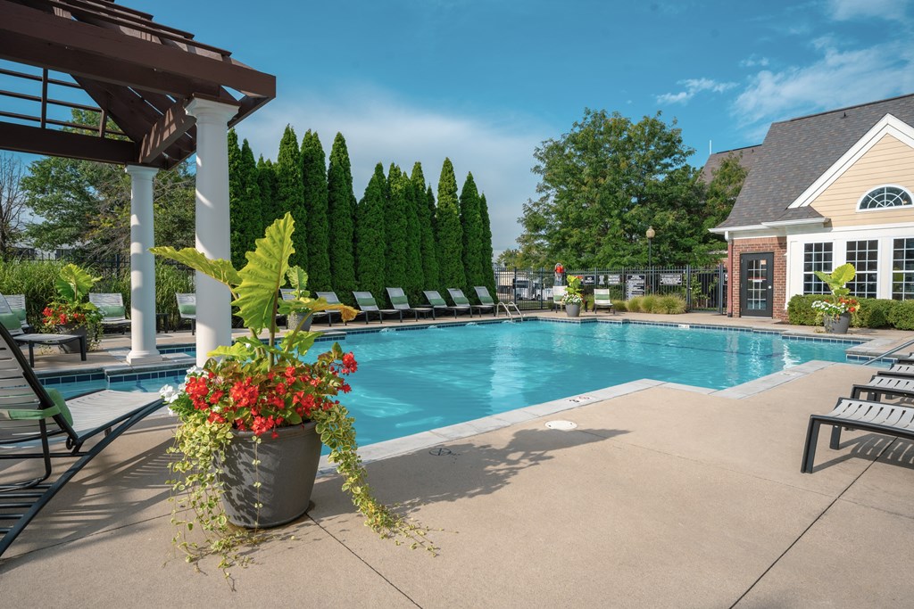 A pool surrounded by trees and a building.