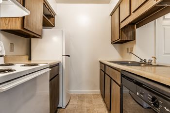 A kitchen with a white stove and a white refrigerator
