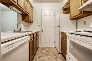 A kitchen with white appliances and wooden cabinets