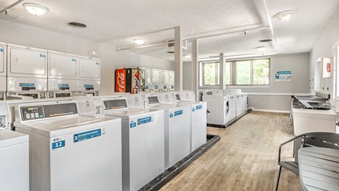A laundromat with washers and dryers labeled E12