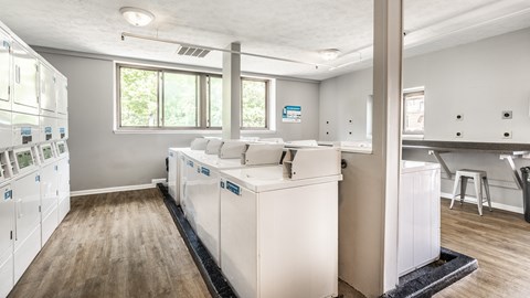A kitchen with white appliances and wooden floors