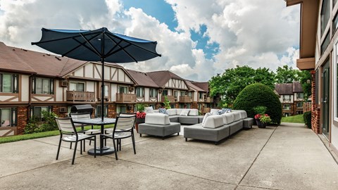 A patio with a table and chairs under an umbrella