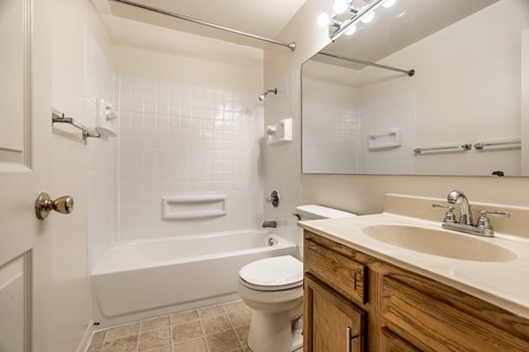 A white toilet sits in a bathroom next to a sink