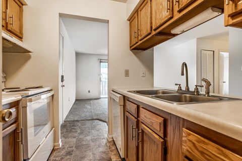 A kitchen with wooden cabinets and a white countertop