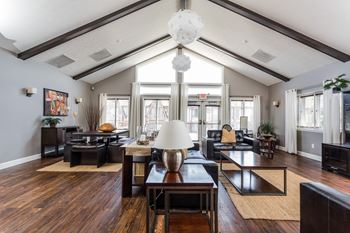 A living room with a wooden floor and a large chandelier at Autumn Woods Apartments, Ohio, 45342