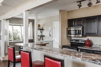 A kitchen with a granite countertop and black cabinets at Autumn Woods Apartments, Miamisburg, OH, 45342