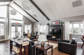 A living room with a black couch, a coffee table, and a fireplace at Autumn Woods Apartments, Miamisburg, OH