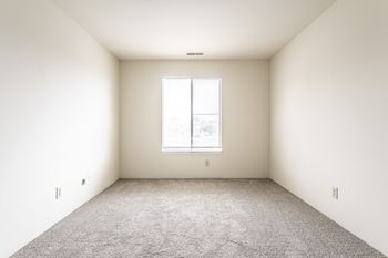 A room with a carpeted floor and a window at Autumn Woods Apartments, Miamisburg, OH
